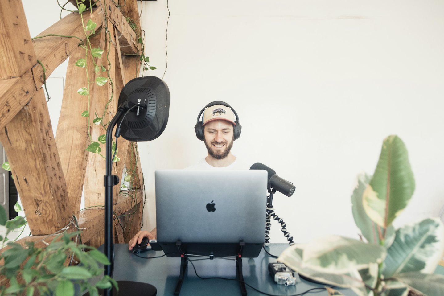 Young man smiling while podcasting at his laptop.